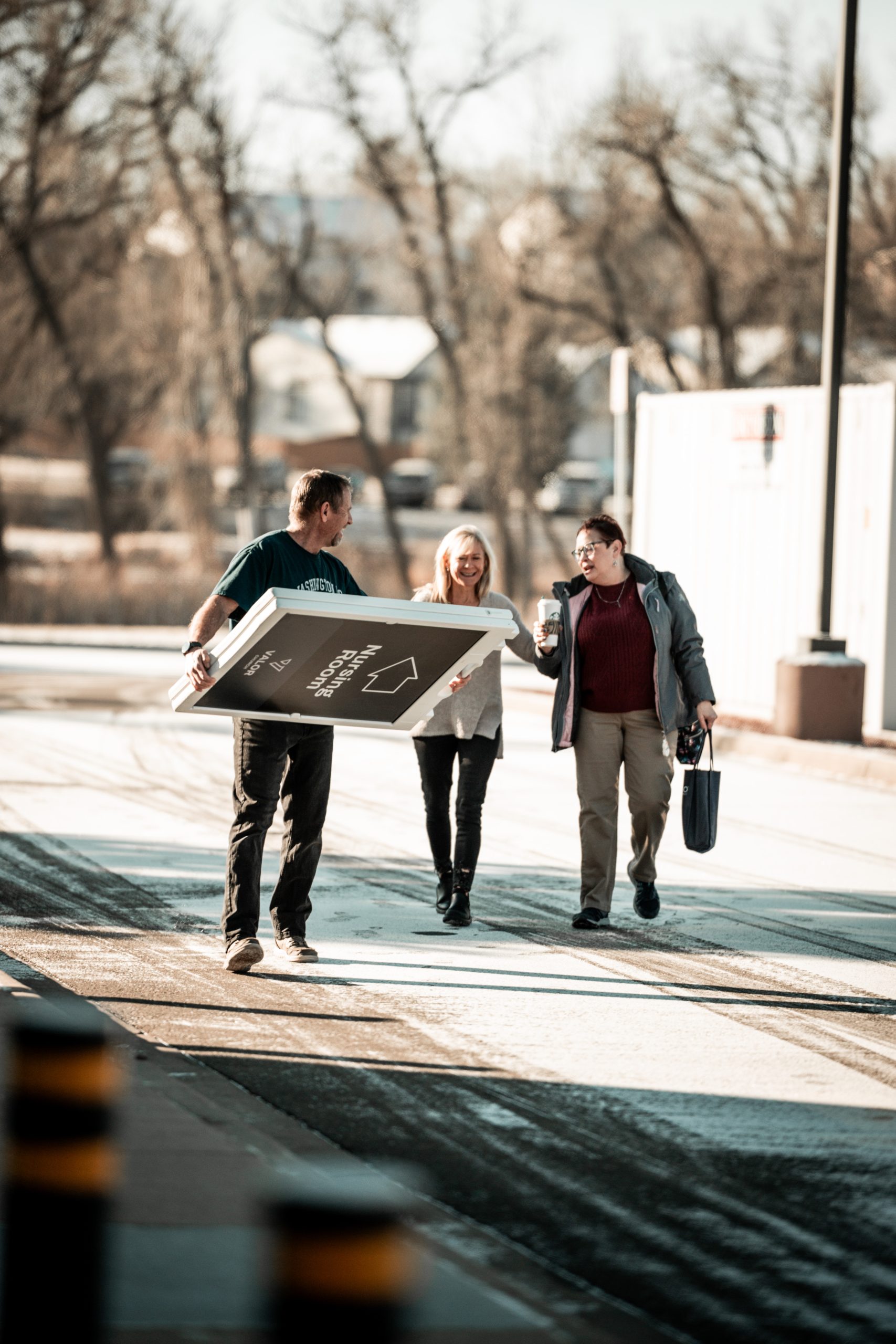 Valor Church volunteers carrying signage while setting up for Sunday in Arvada